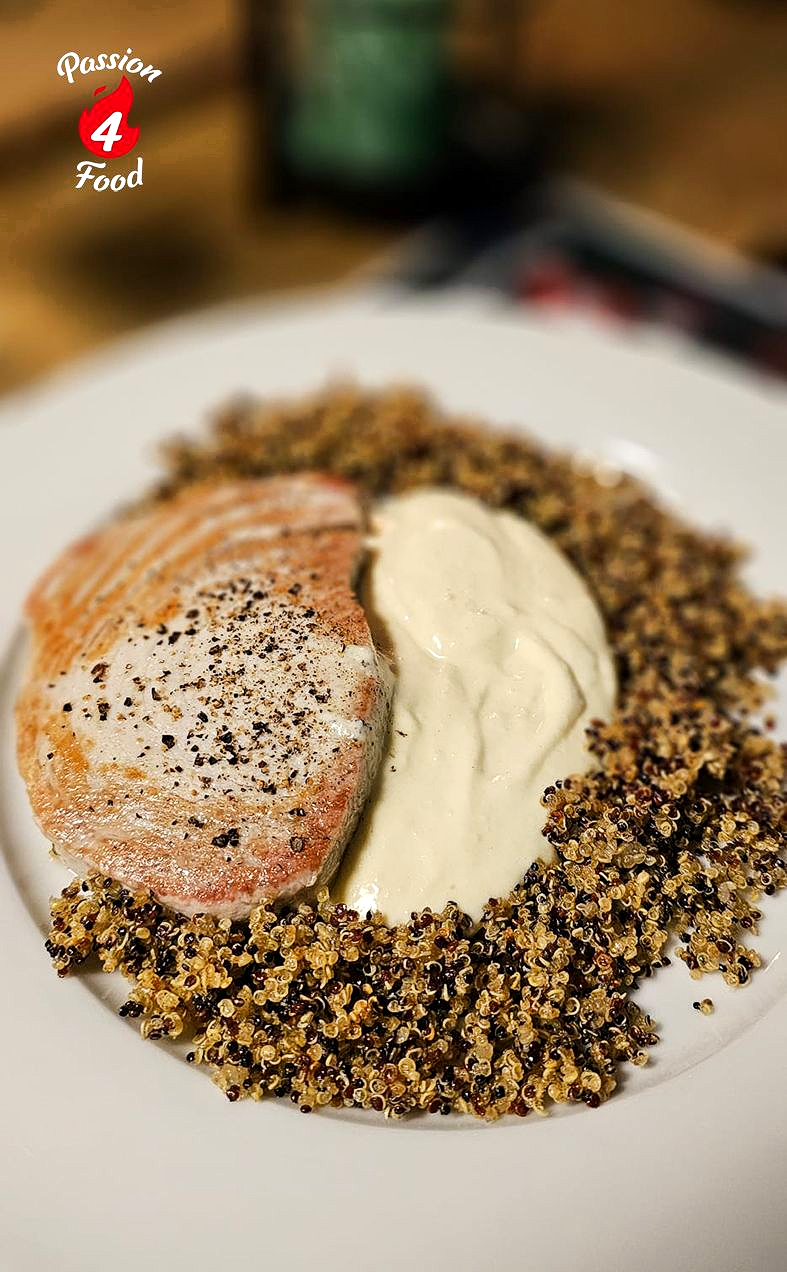 Gegrilde rode tonijn op wit bord met gefrituurde quinoa en ajo blanco.