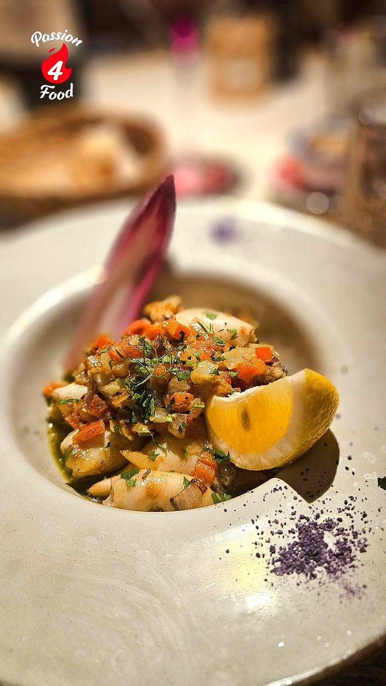 Gestoofde baby-inktvis met uien, tomaten en witte wijn