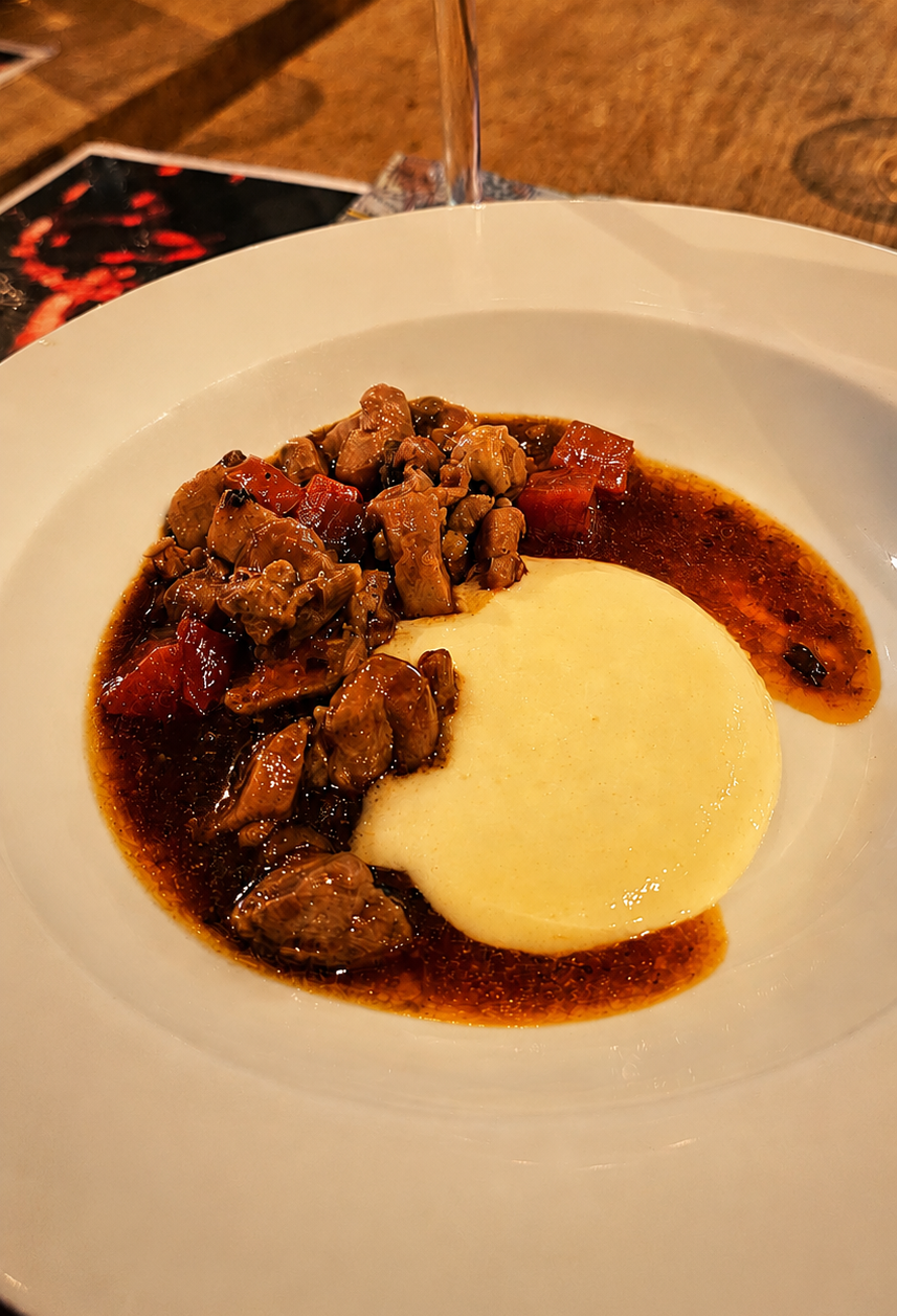 Een bord met sappige stukjes kippendij met fluweelzacht aardappelschuim en verse truffel.