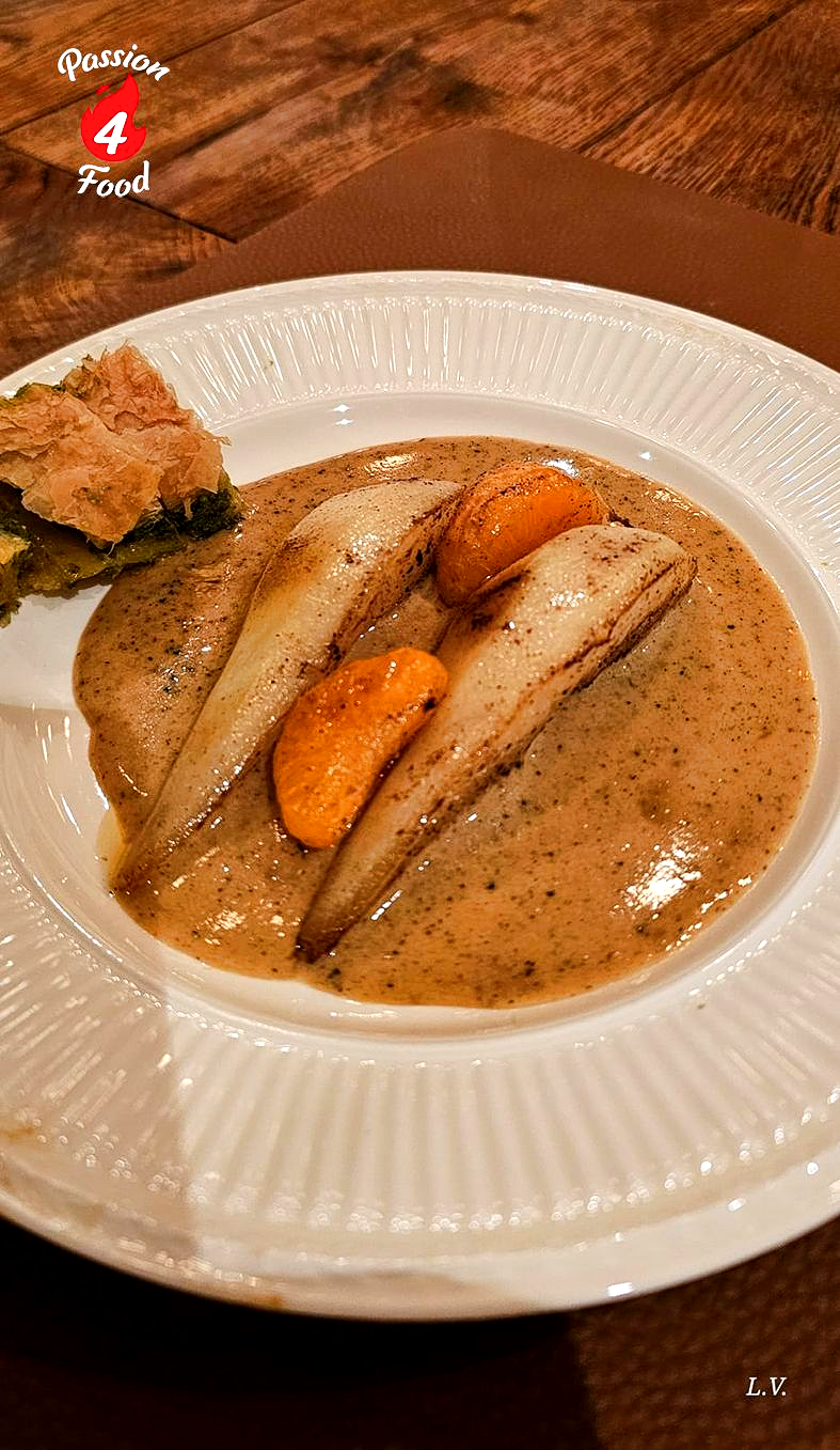 Wit bord, peren in roomsaus en baklava. Dessert.