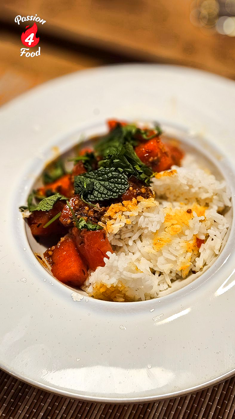 Wit bord op houten tafel met Rajasthani Matira Curry. Ook bekend als Watermeloen Curry.