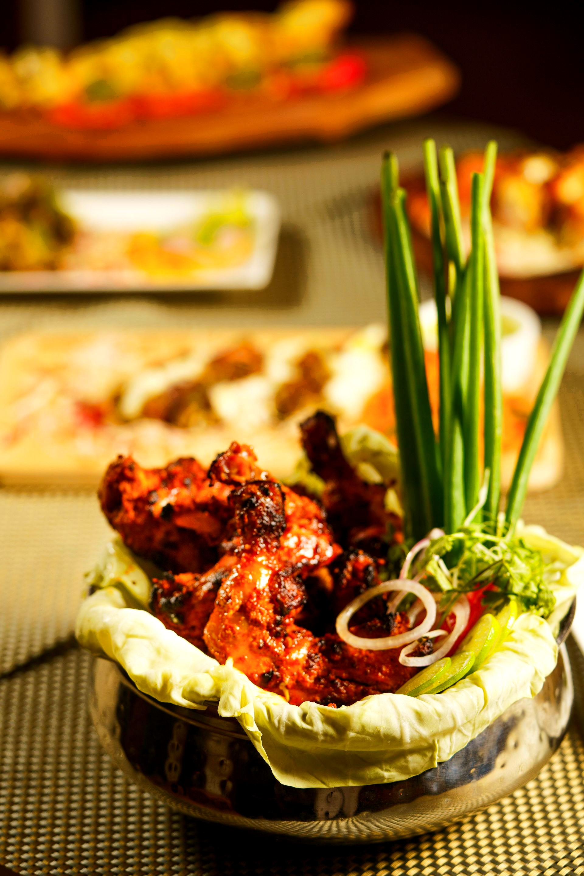 Kip Tandoori in een mooie kom met wat stengels lenteui. 