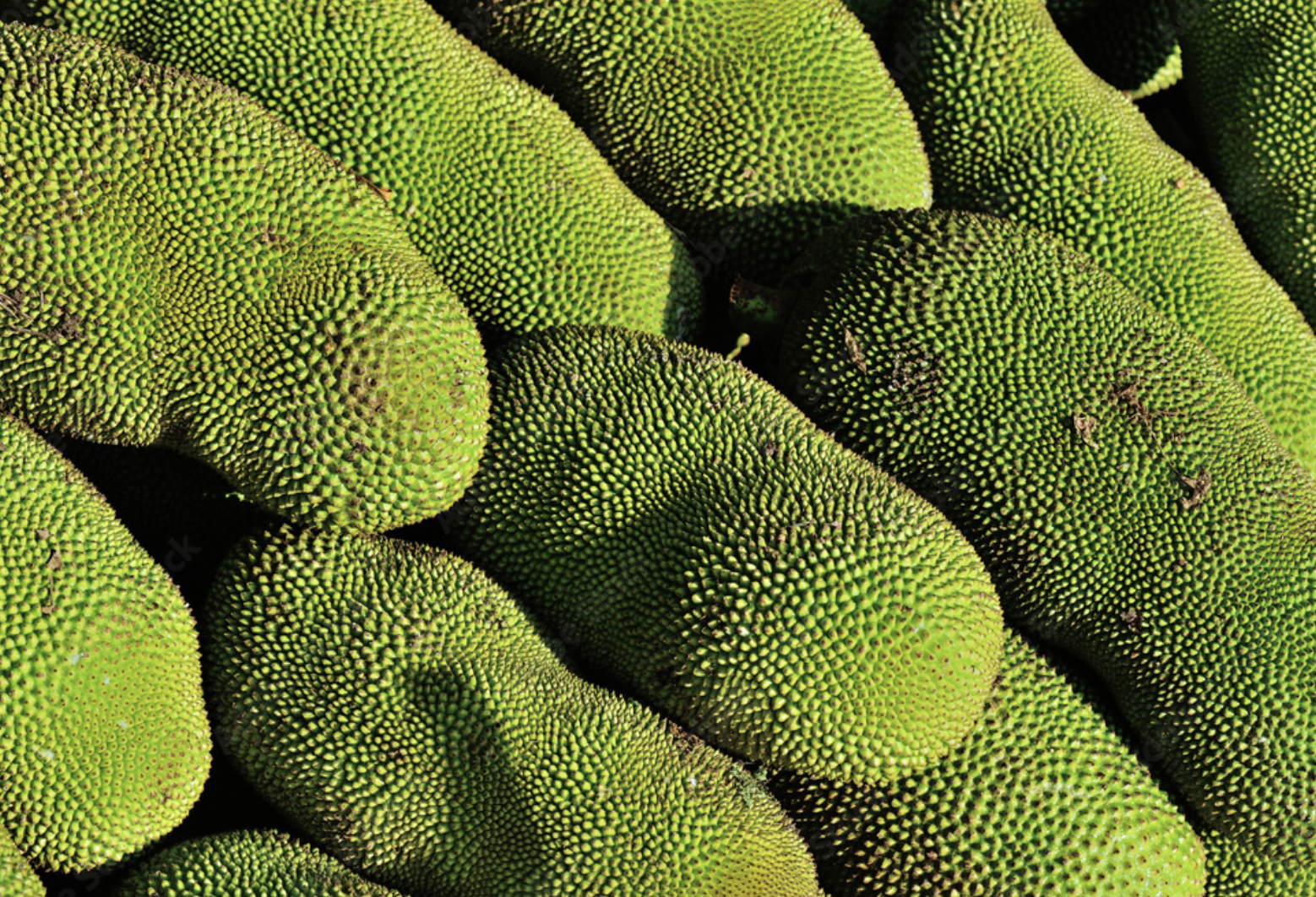 Un montón de frutas verdes se apilan una encima de otra.