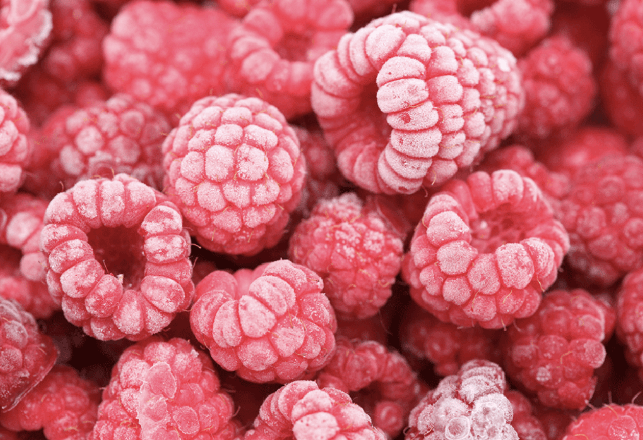 Un montón de frambuesas están colocadas una encima de otra.