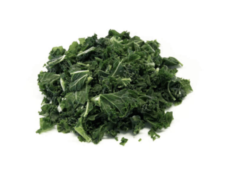 Un montón de hojas de col rizada picadas sobre un fondo blanco.