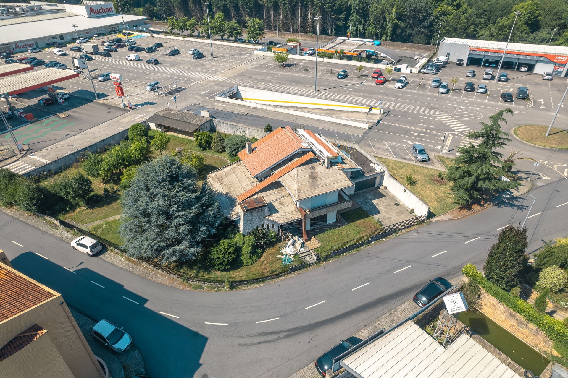 Uma vista aérea de uma casa com o telhado a ser substituído para painel sandwich imitação de telha lusa 45mm laranja RAL8004