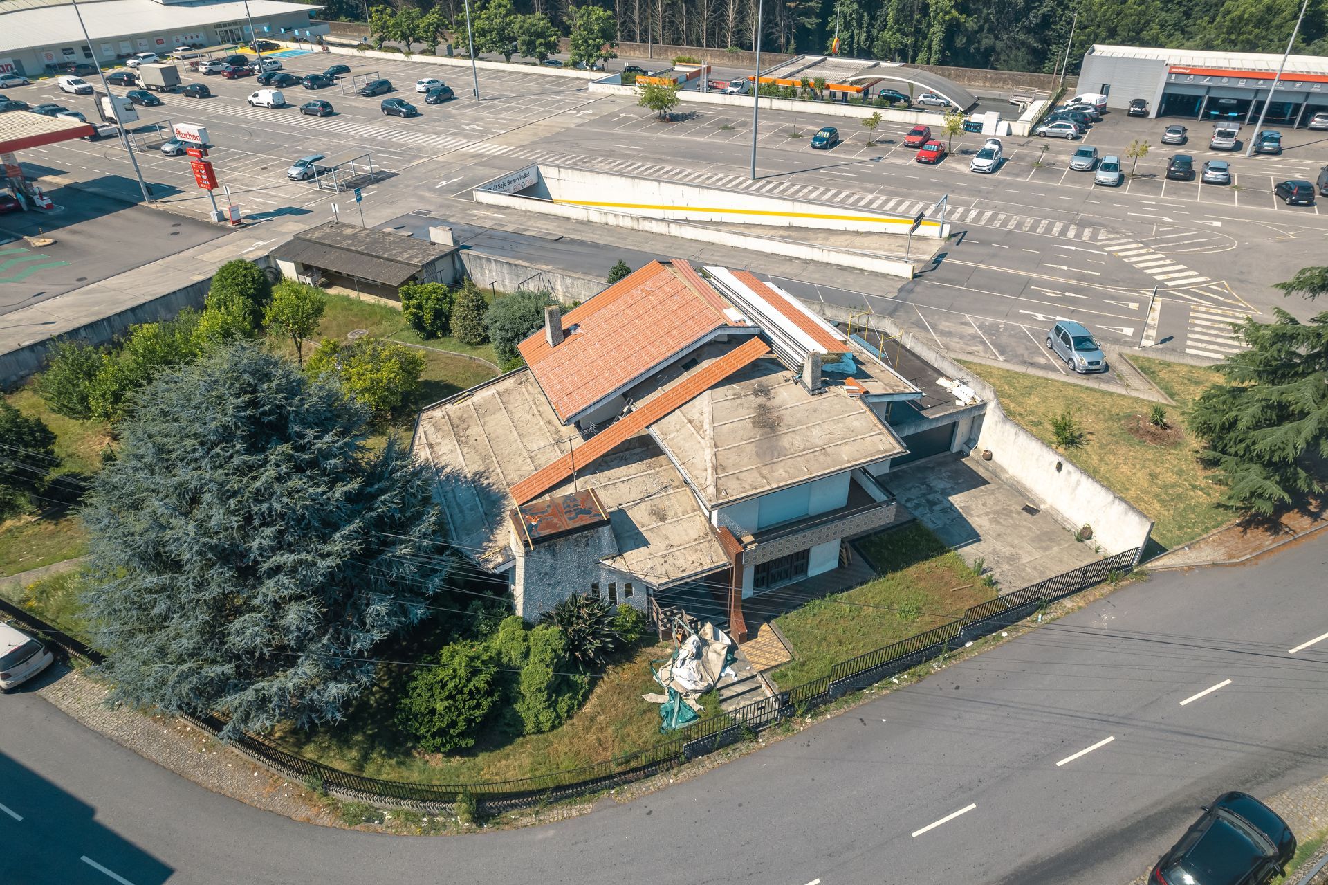 Uma vista aérea de uma casa com o telhado a ser substituído para painel sandwich imitação de telha lusa 45mm.