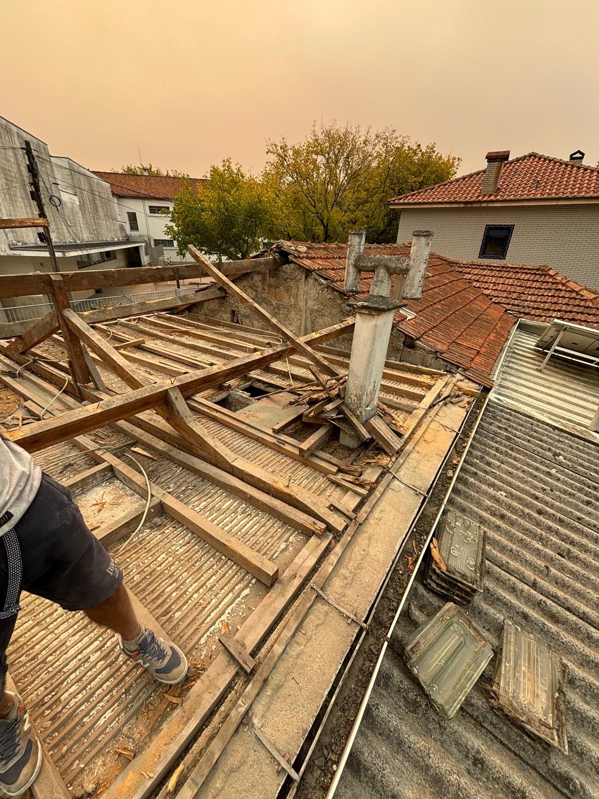 Um homem está trabalhando no telhado de um prédio.