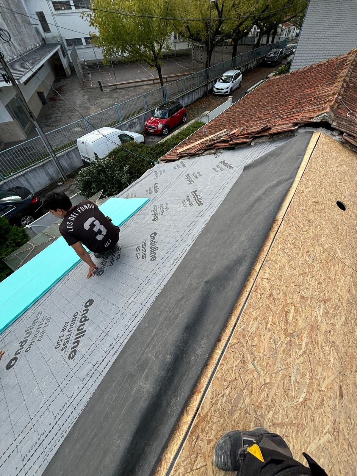Um homem está trabalhando no telhado de uma casa forrado com madeira OSB e com filme impermeável ONDUTISS AIR 150g.