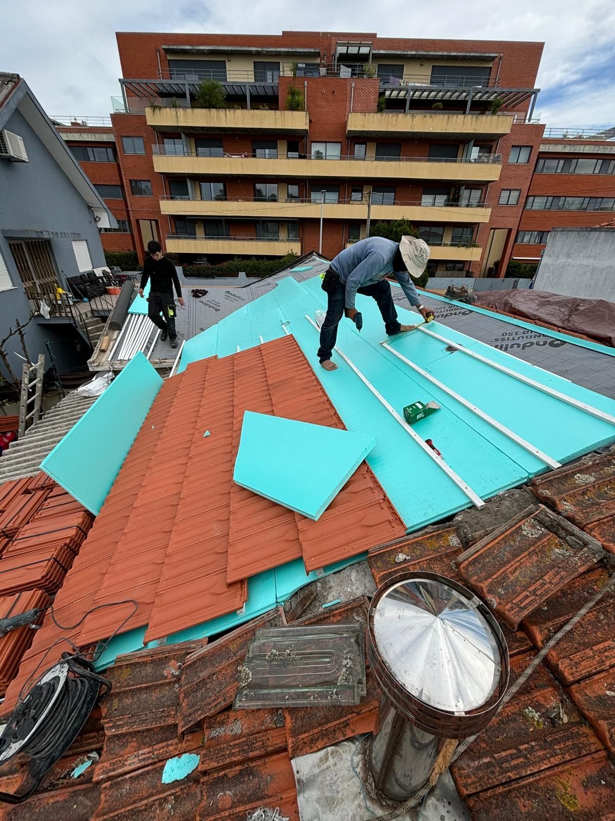 Um homem está trabalhando no telhado de um prédio.