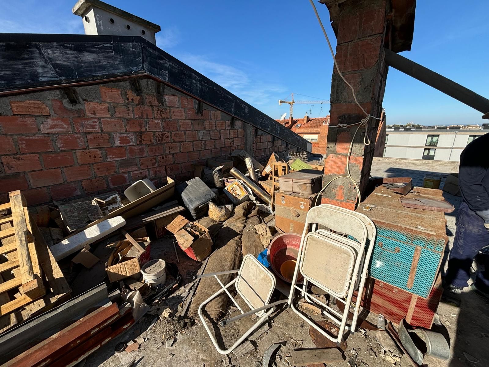 Uma pilha de lixo está no telhado de um prédio.