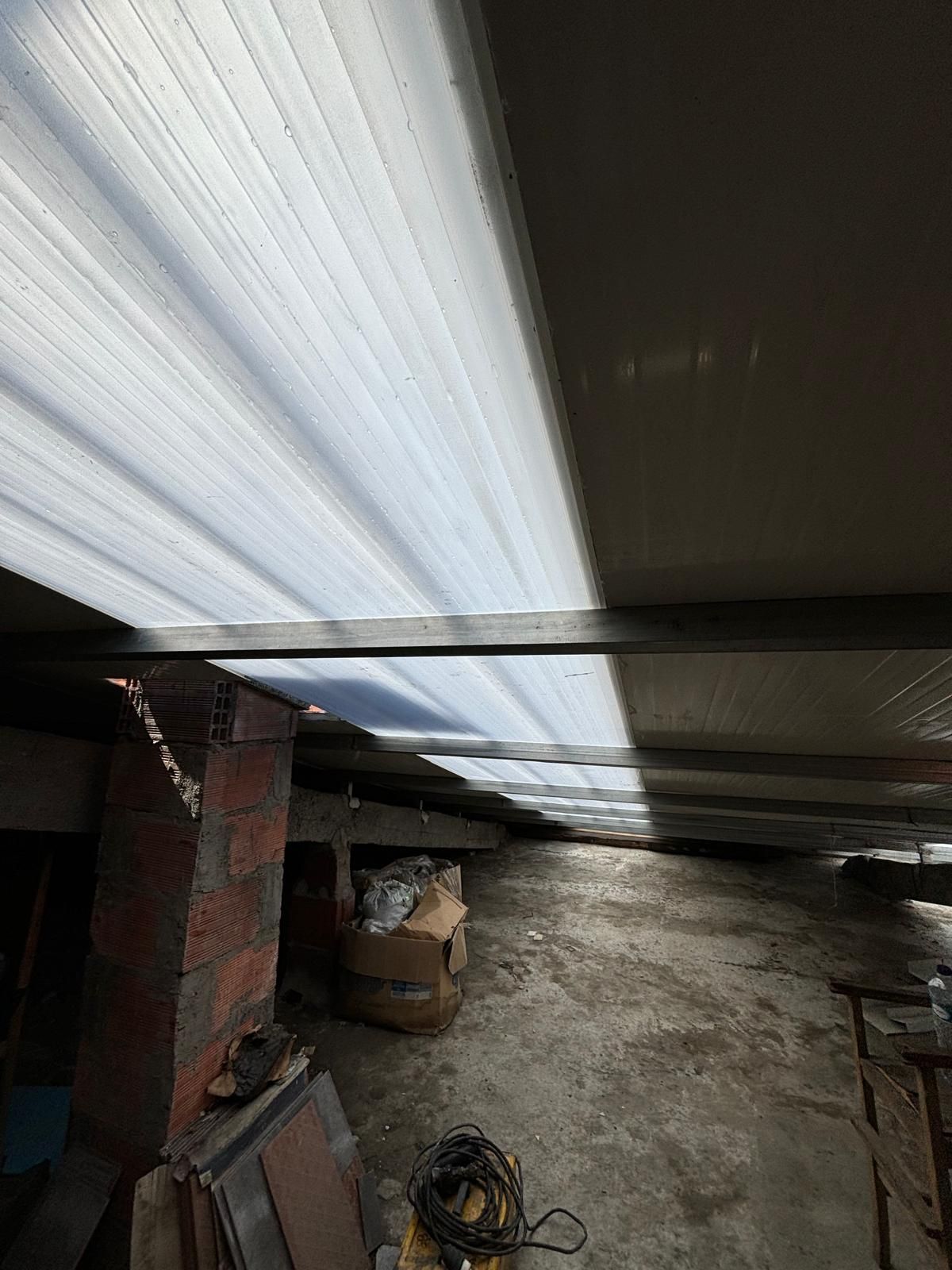 Há muita luz entrando pelo teto de um prédio através de uma telha translucida 5 ondas