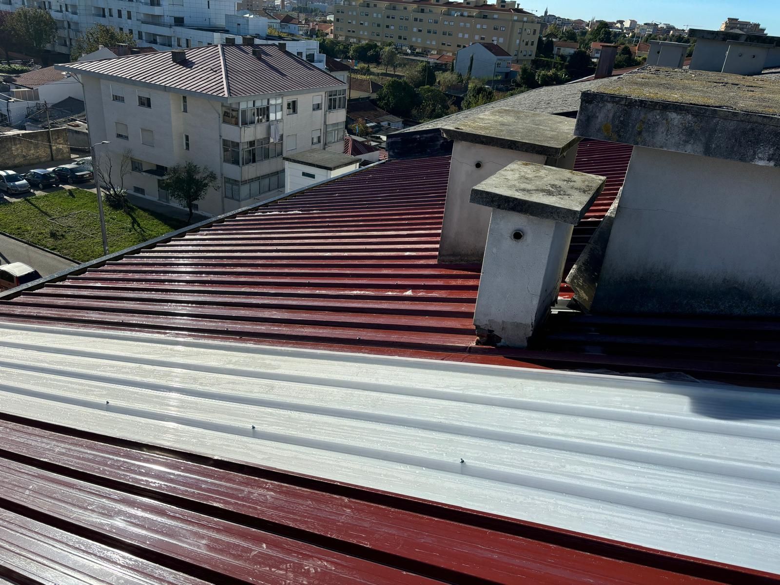 Um telhado vermelho e telha translucida 5 ondas com uma chaminé em cima