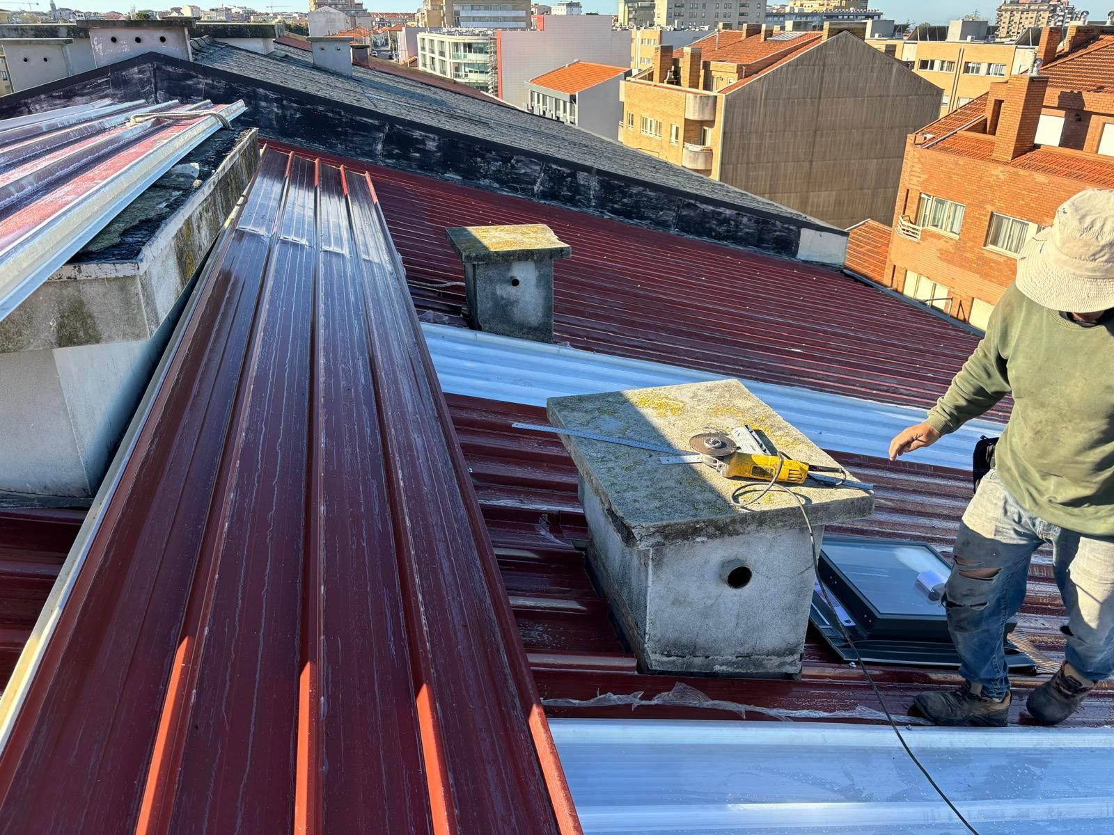 Um homem está trabalhando no telhado de um prédio.