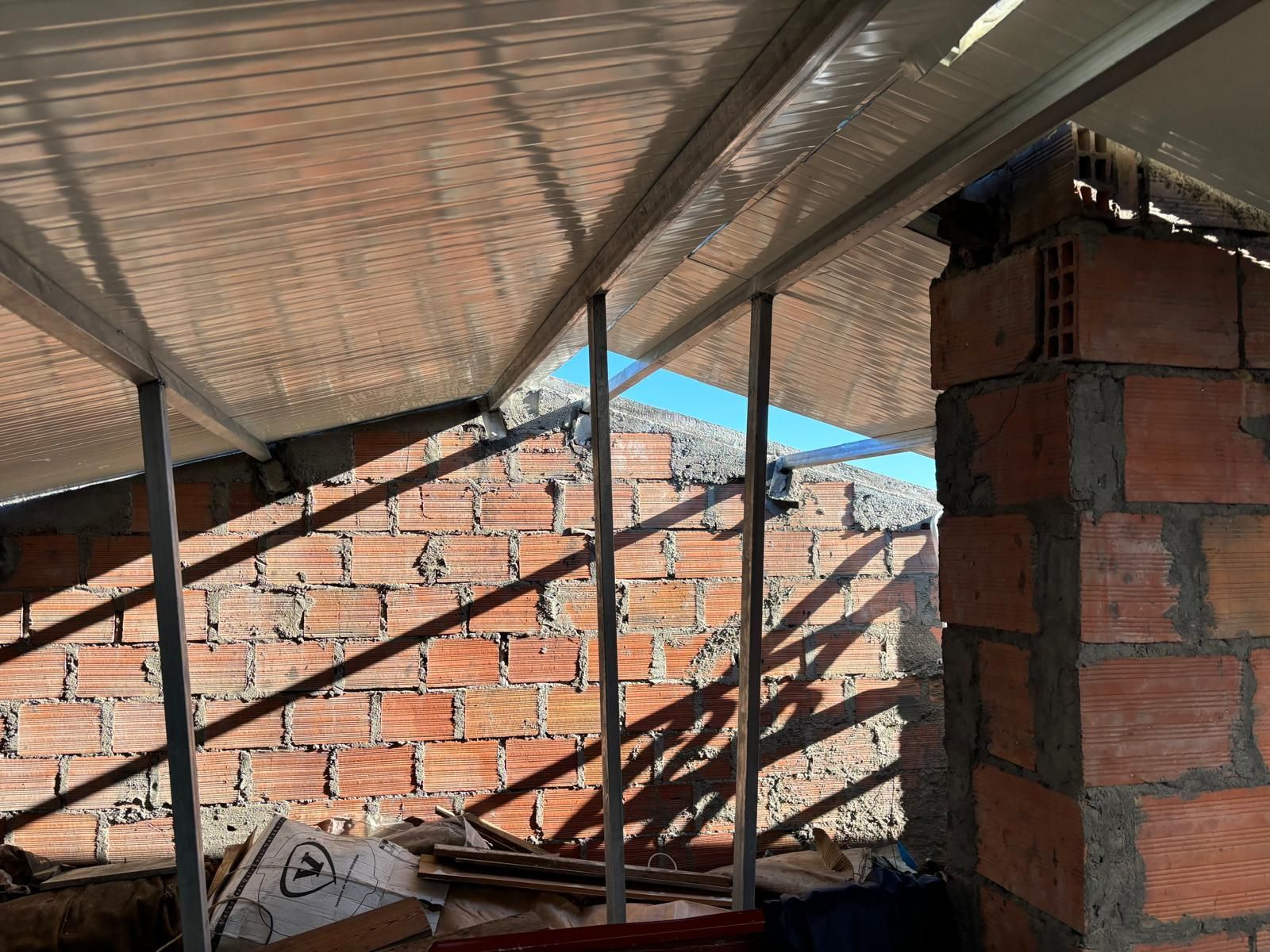 Uma parede de tijolos com um telhado que está sendo construído