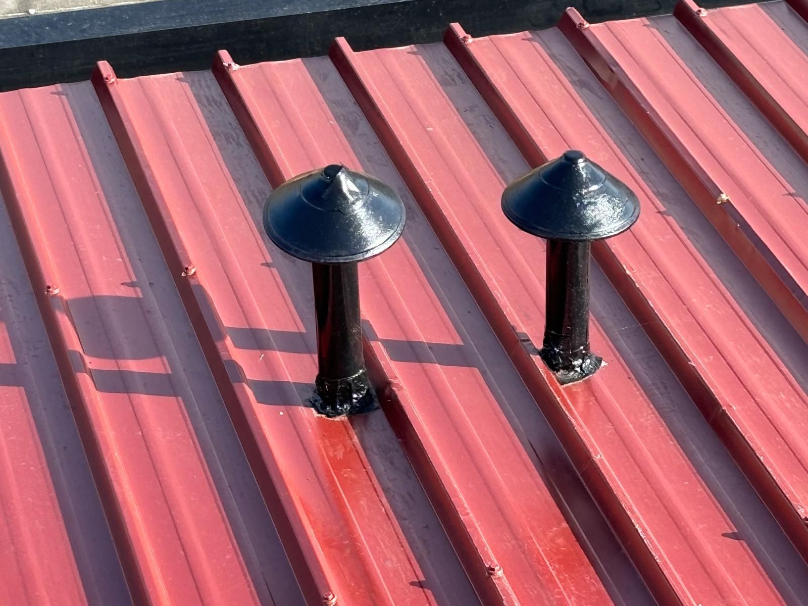 Um telhado vermelho em painel sandwich 5 ondas 30mmcom duas chaminés pretas