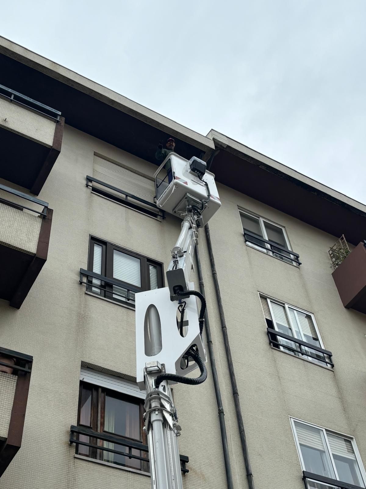 Um grande edifício com uma Grua usada para pintar os tubos de queda de um prédio