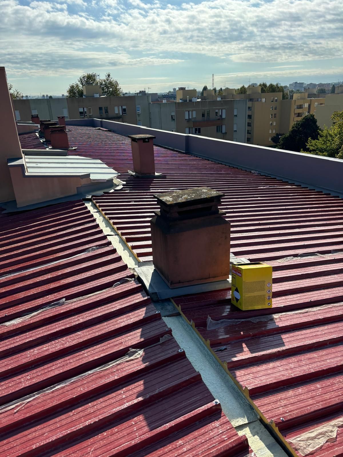 telhado em painel sandwich 5 ondas 30mm RAL3009 vermelho com uma chaminé em cima.