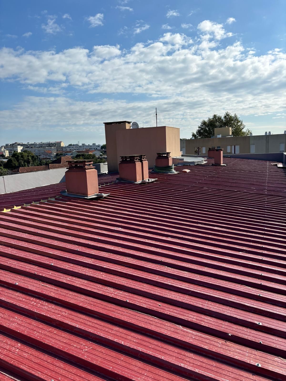Um telhado vermelho com chaminés em cima