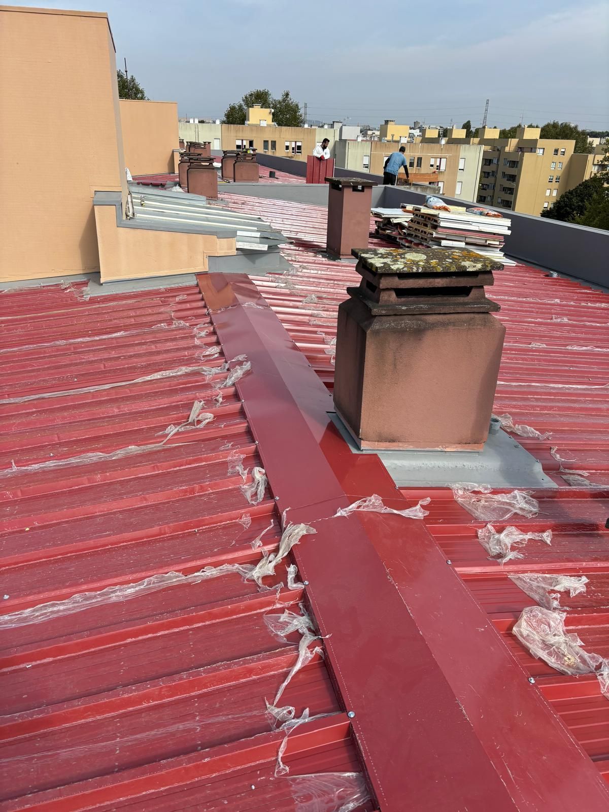 Um telhado vermelho com uma chaminé em cima