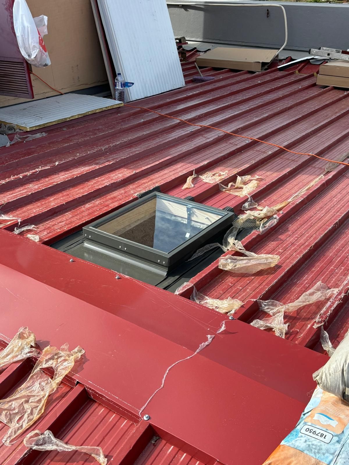 Um telhado vermelho com uma claraboia no meio.