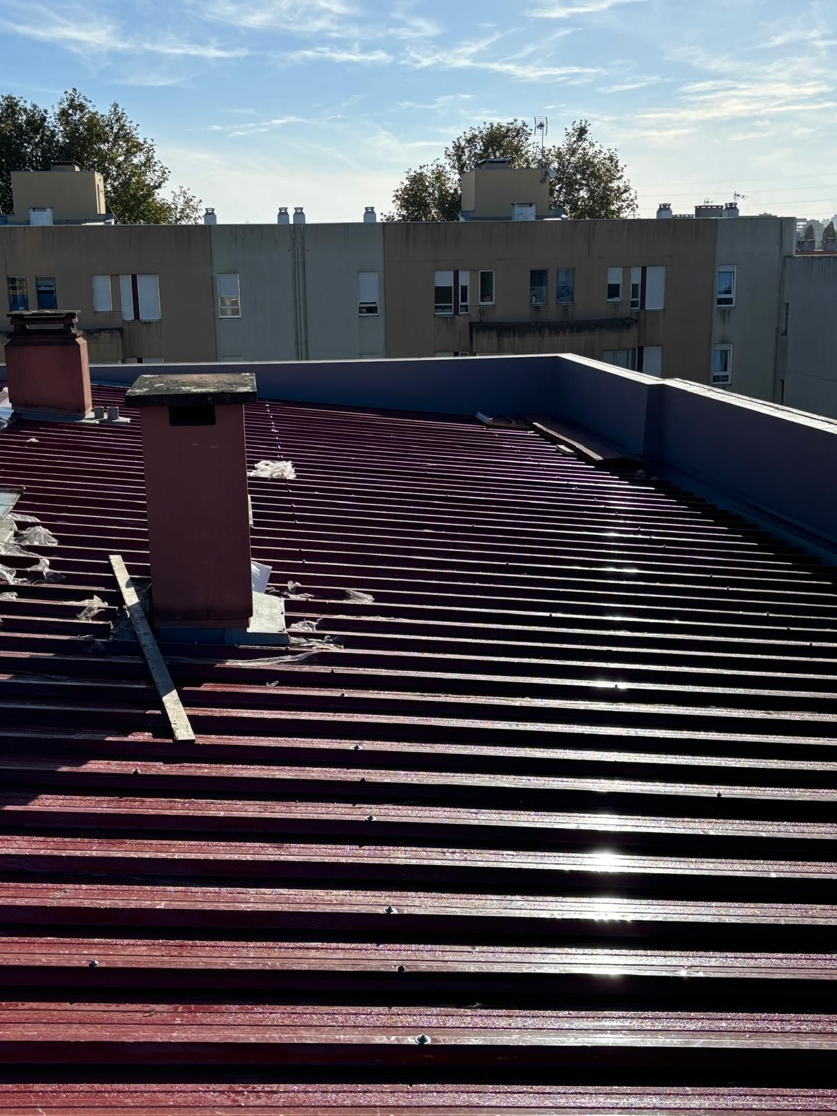 Um telhado vermelho com uma chaminé em cima
