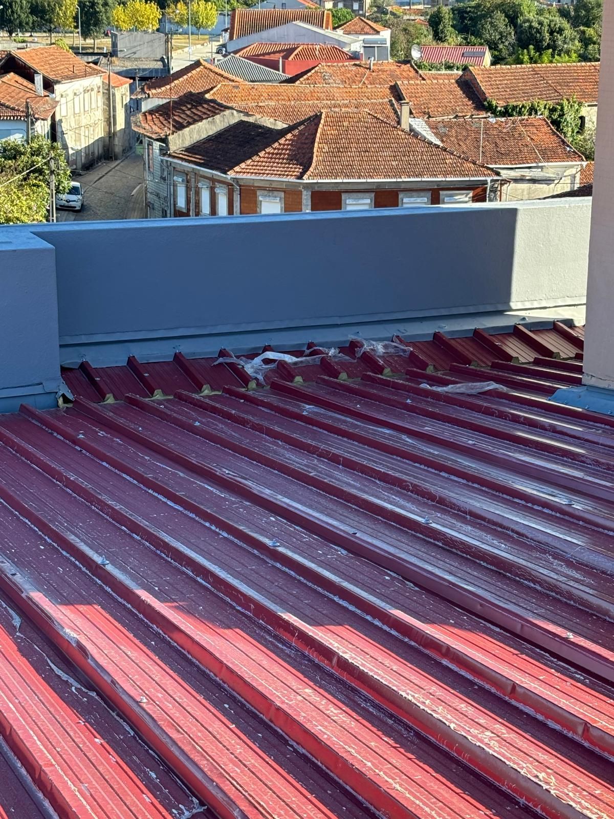 Um telhado de metal telhado em painel sandwich 5 ondas 30mm RAL3009 vermelho com uma chaminé em cima.