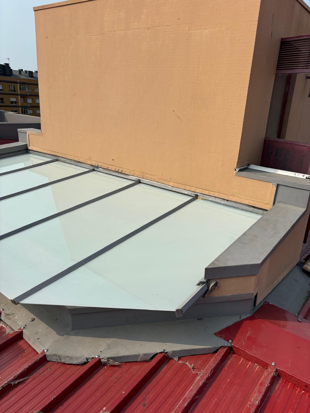 Um telhado com uma claraboia finalizada com vidros laminados e impermeabilização de estrutura em cinzento no telhado e beiras