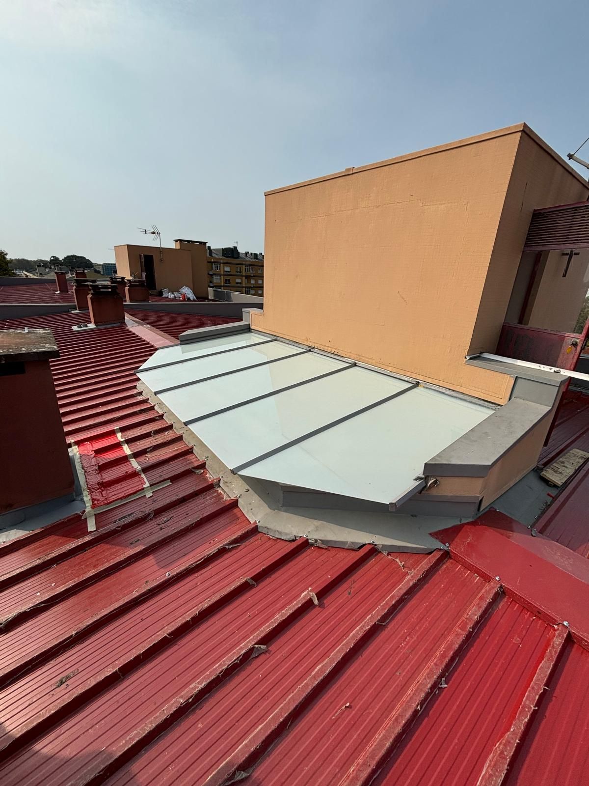 Um telhado em painel sandwich 5 ondas 30mm RAL3009 vermelho com uma cobertura branca em cima