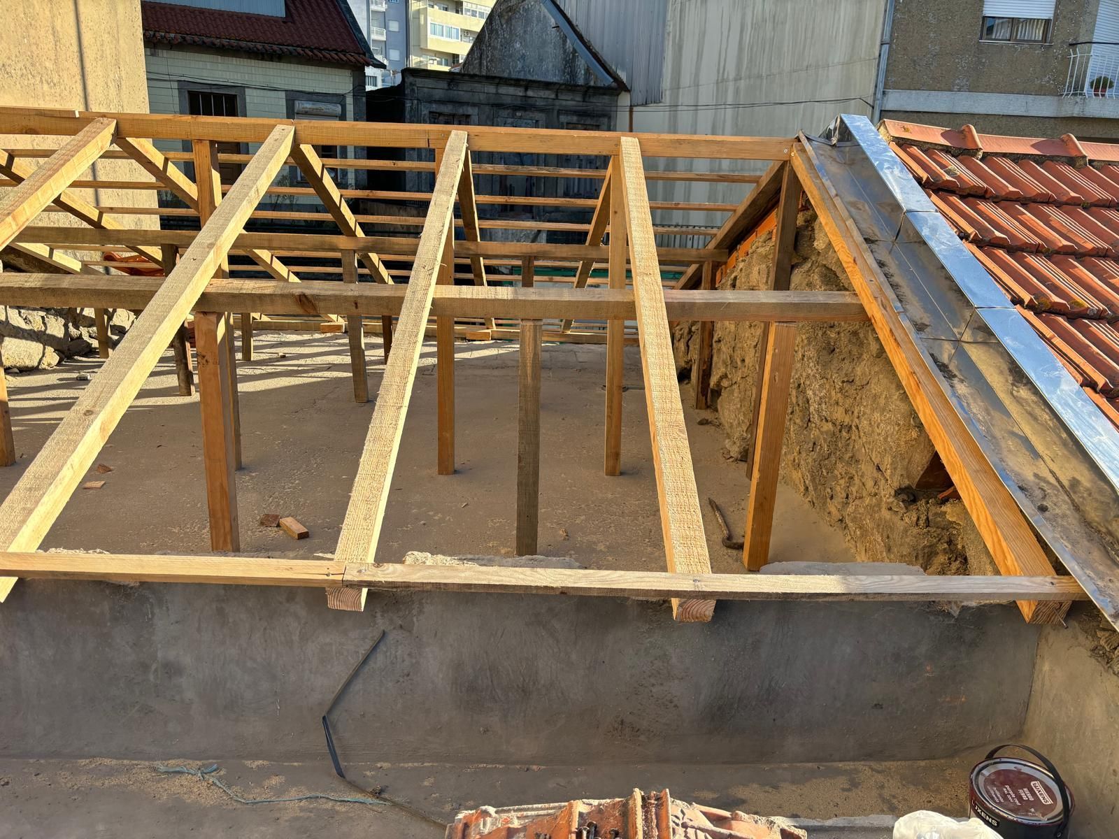 Uma estrutura nova de madeira está sendo construída no telhado de um edifício.