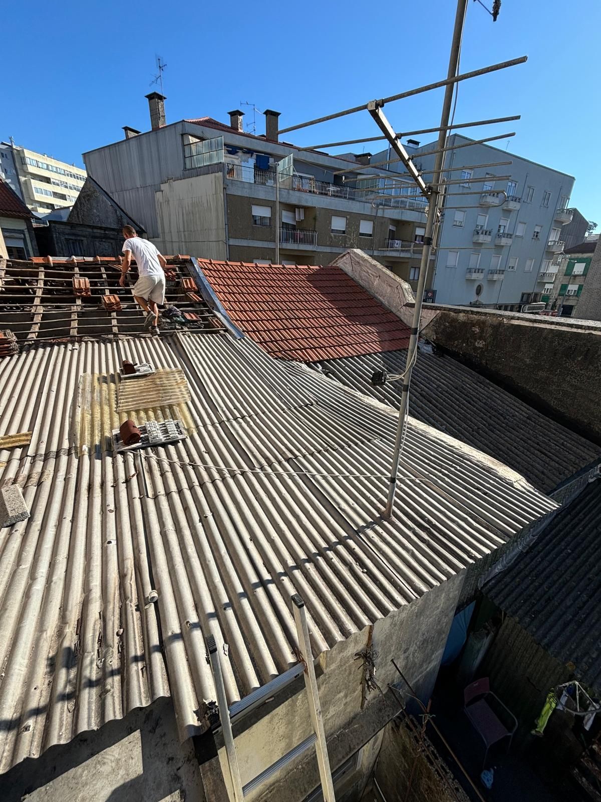 Um homem está trabalhando no telhado de um prédio.
