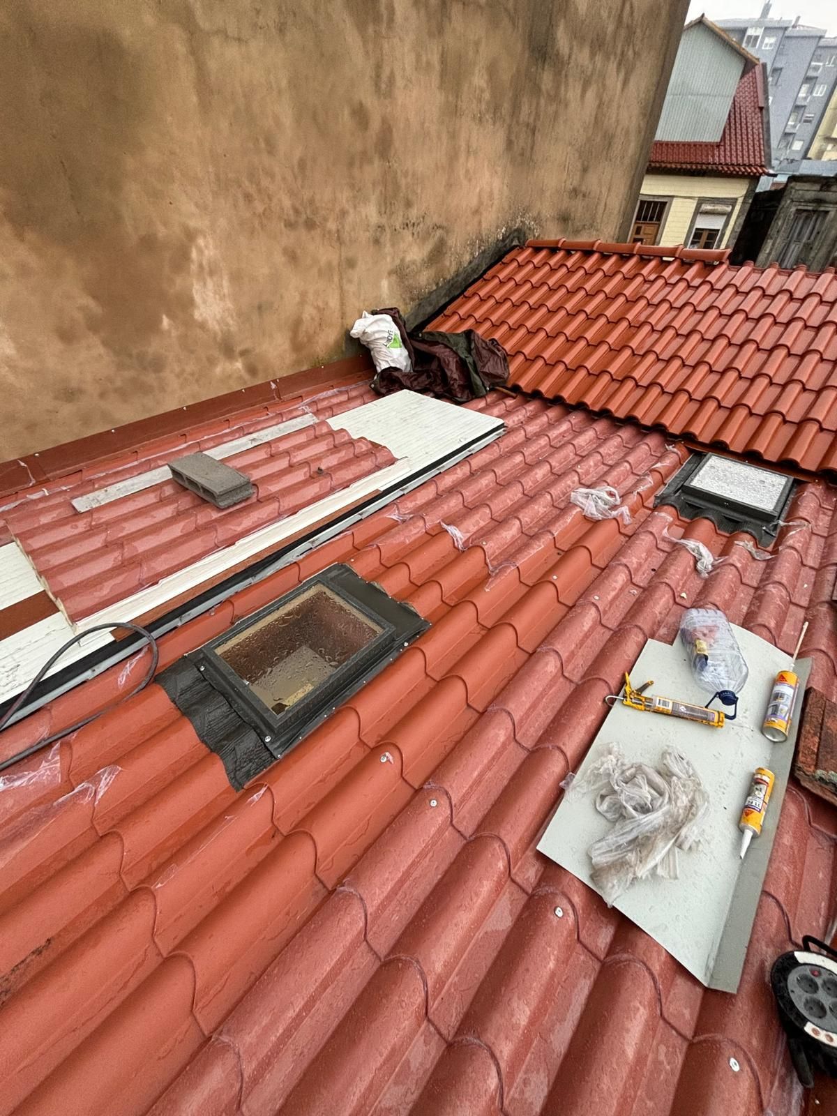 Um telhado com telhas vermelhas e uma claraboia.