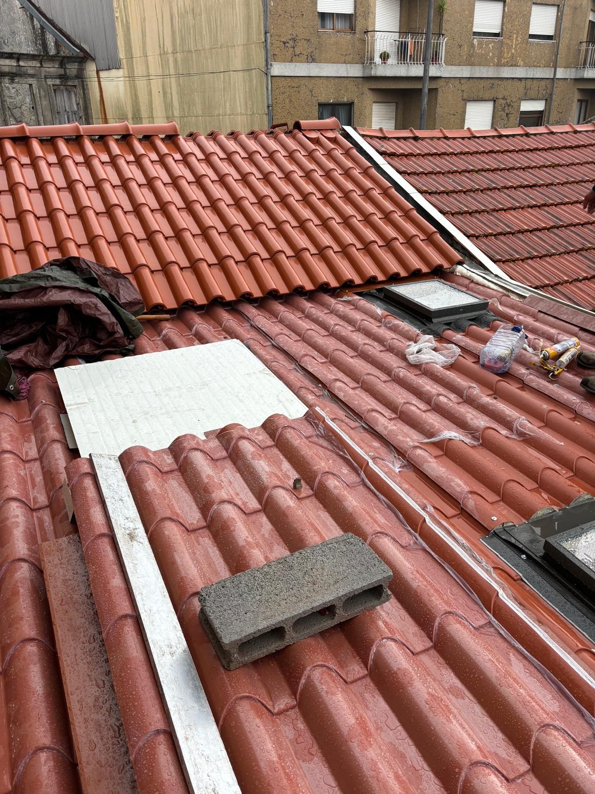 Um telhado com telhas vermelhas e um bloco branco em cima.