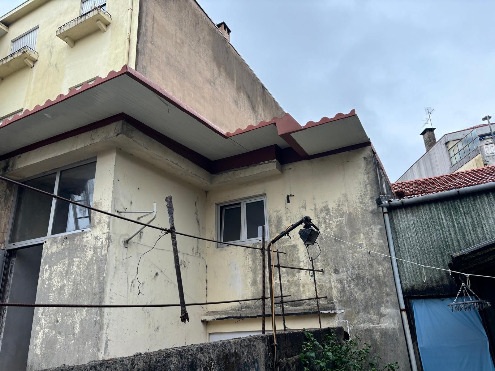 Um prédio amarelo com um telhado vermelho e uma porta azul