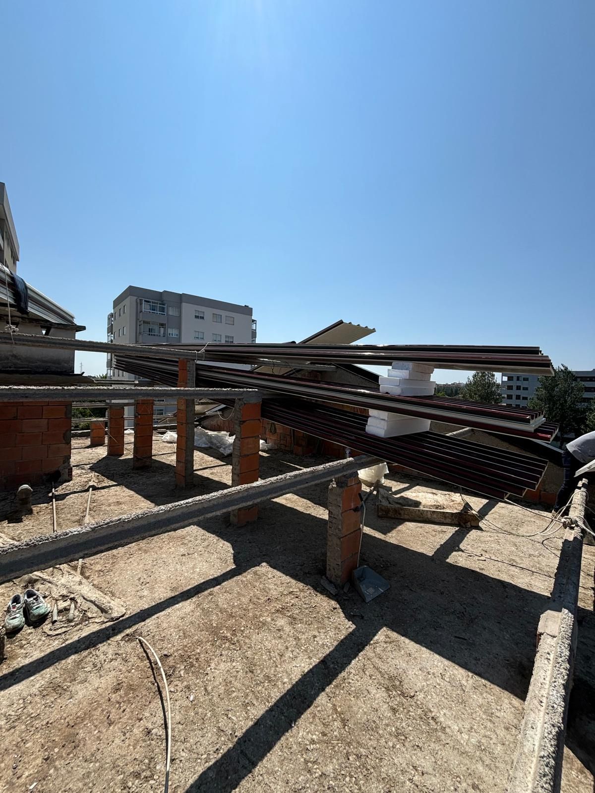 Um telhado com muitas barras de metal e um prédio ao fundo.