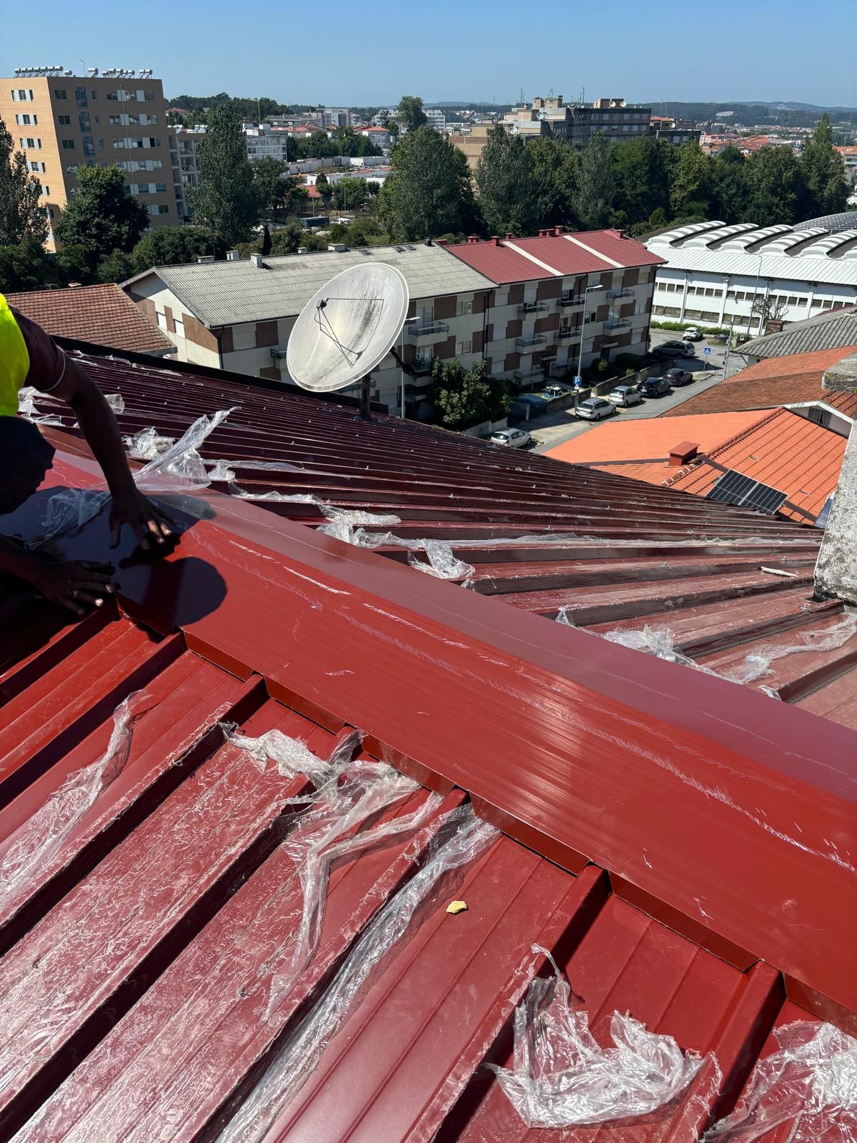 Um homem está pintando o telhado de um prédio.