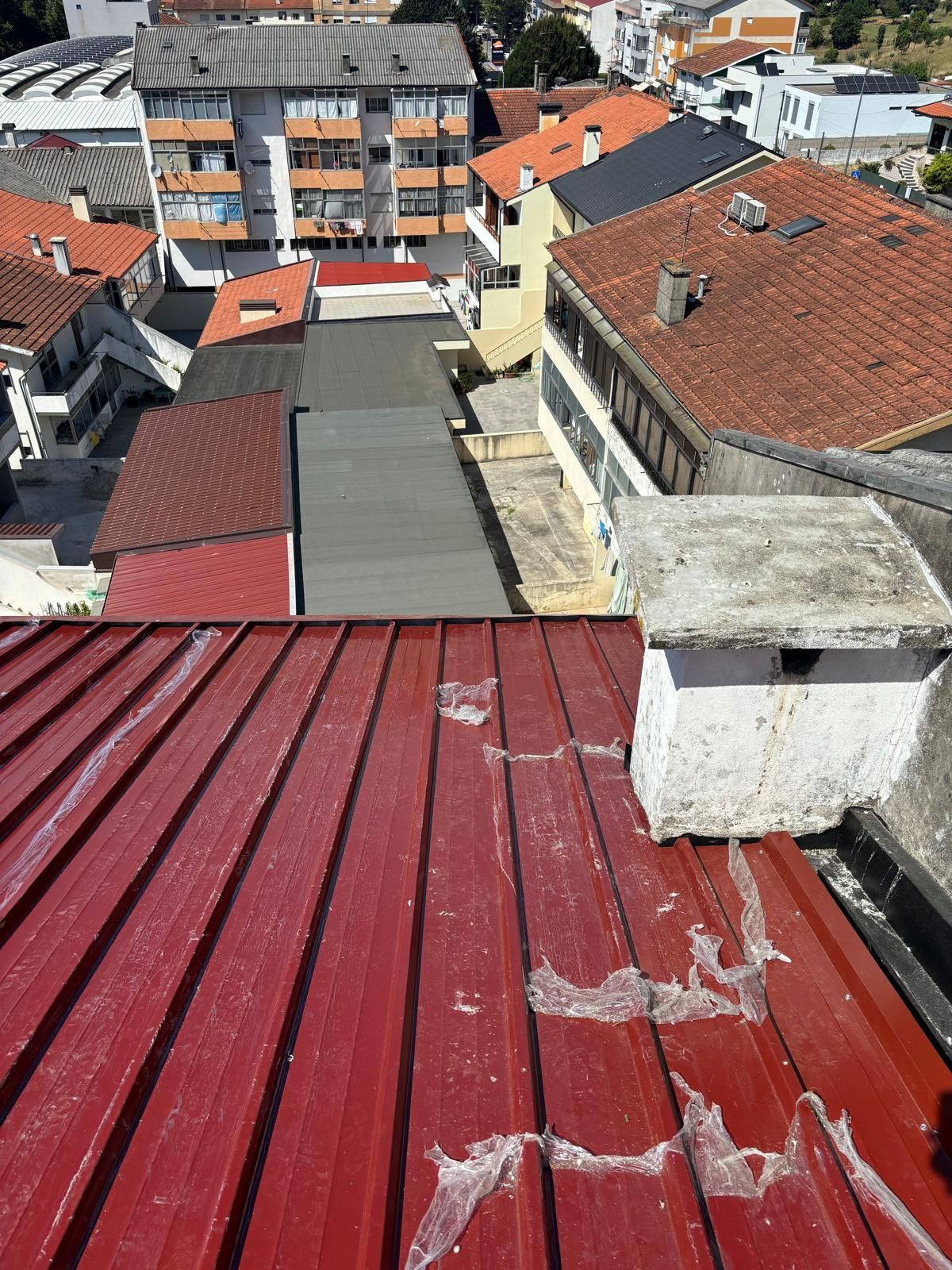 Um telhado vermelho com uma chaminé em cima