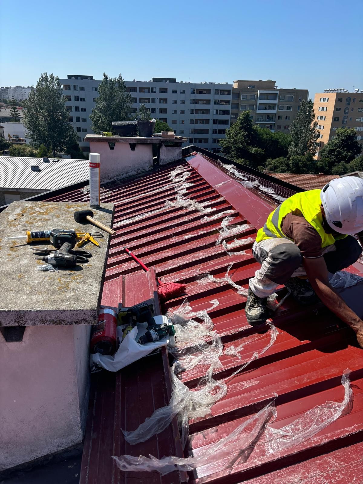 Um homem está trabalhando no telhado de um prédio.