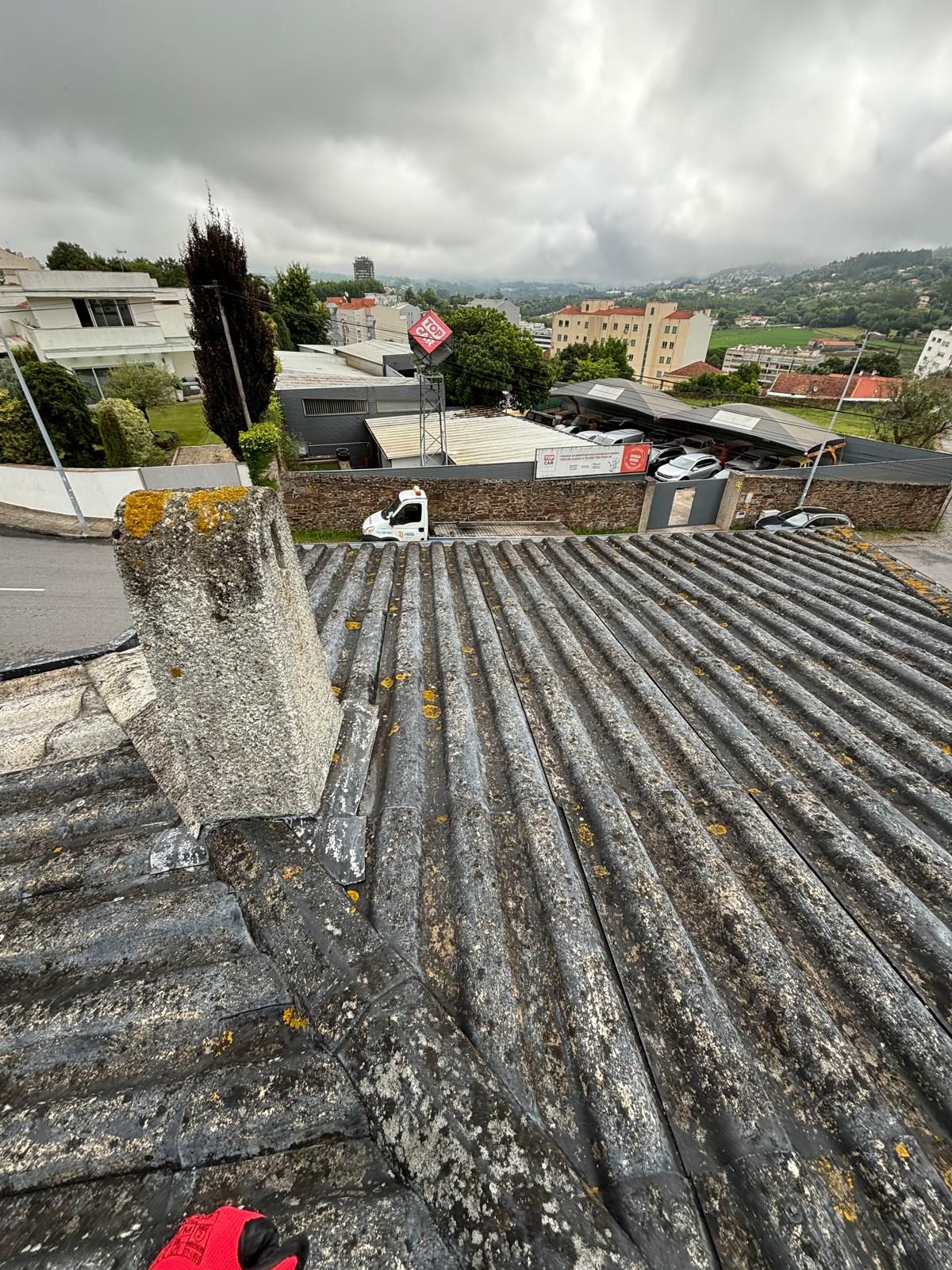Um telhado com uma chaminé no topo e uma vista de uma cidade.