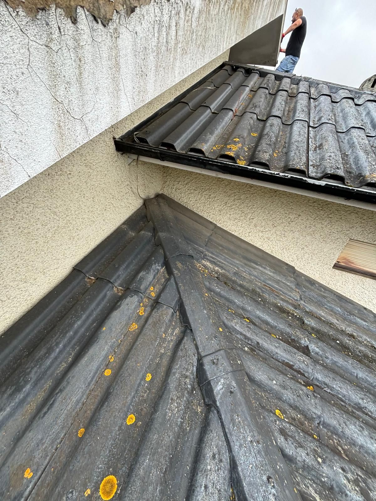 Um homem está em pé no topo de um telhado.