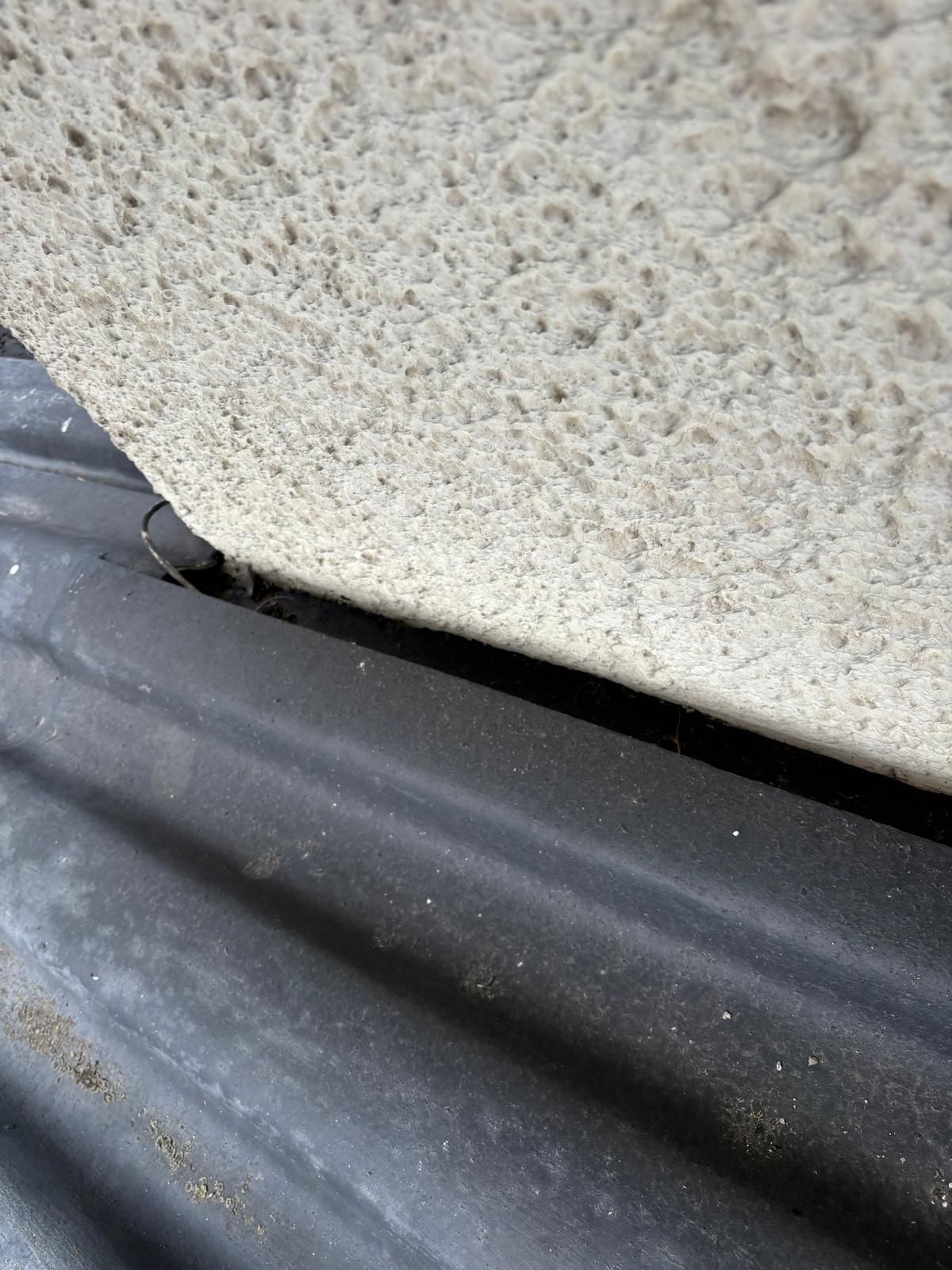 Uma parede de concreto está sobre um telhado preto.