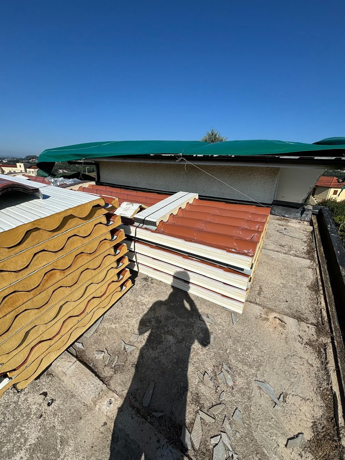 Uma pessoa está parada em frente a uma pilha de painéis de cobertura.