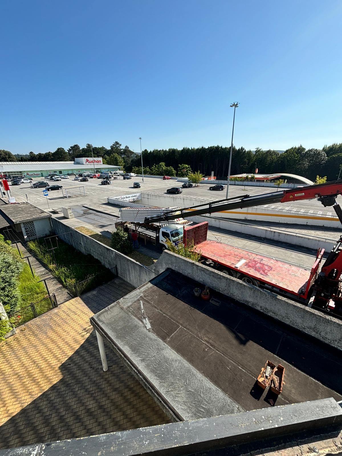Uma vista aérea de um estacionamento com um caminhão grua e um guindaste.