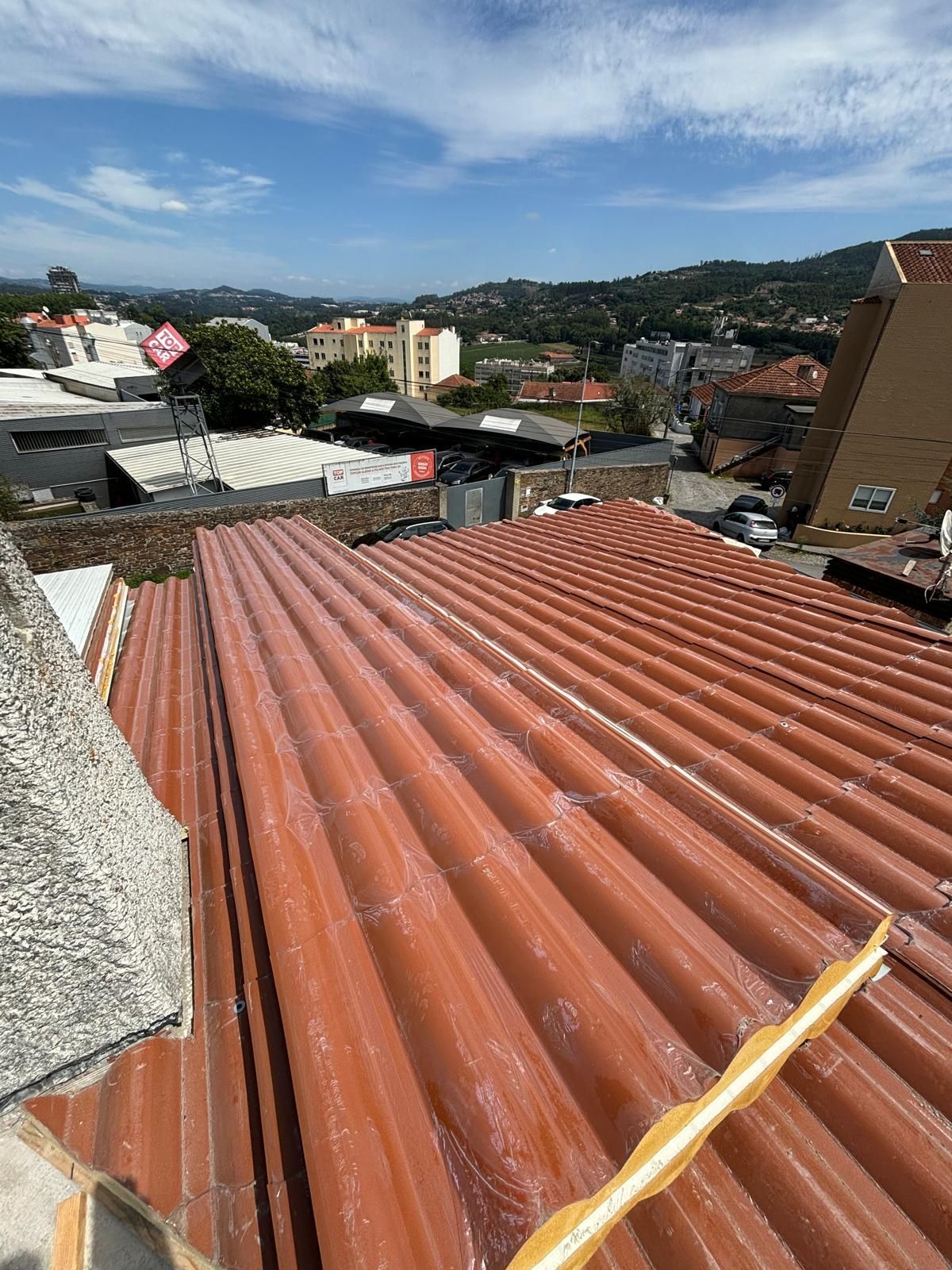 O telhado de um edifício com painel sandwich imitação de telha lusa 45mm laranja RAL8004.