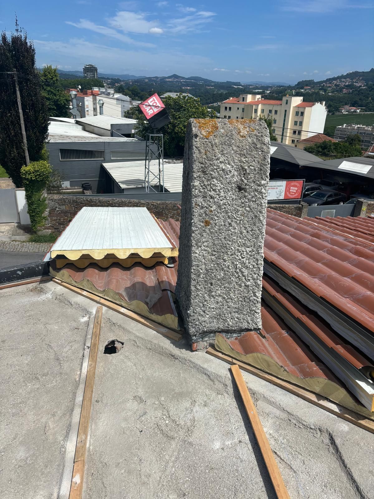 Uma chaminé está no telhado de um prédio com painel sandwich imitação de telha lusa 45mm laranja RAL8004