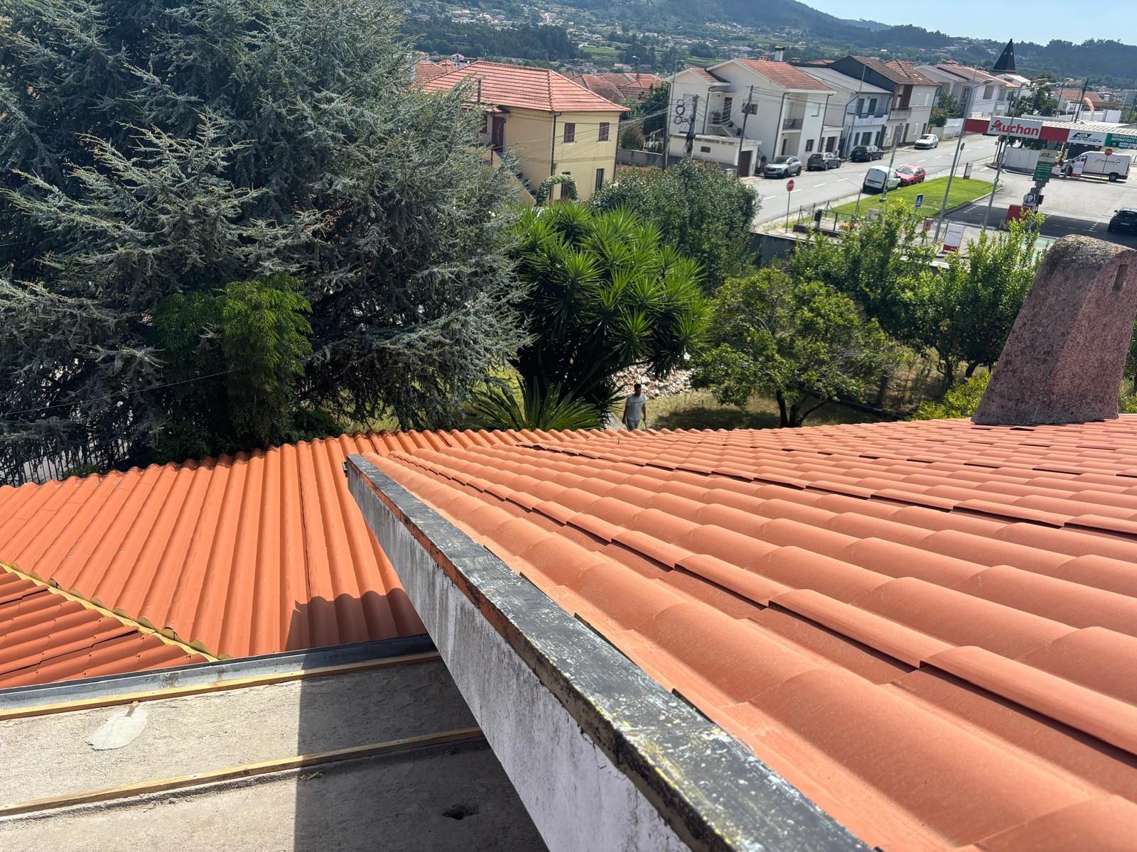 Um telhado em painel sandwich imitação de telha lusa 45mm laranja RAL8004 com uma calha na lateral