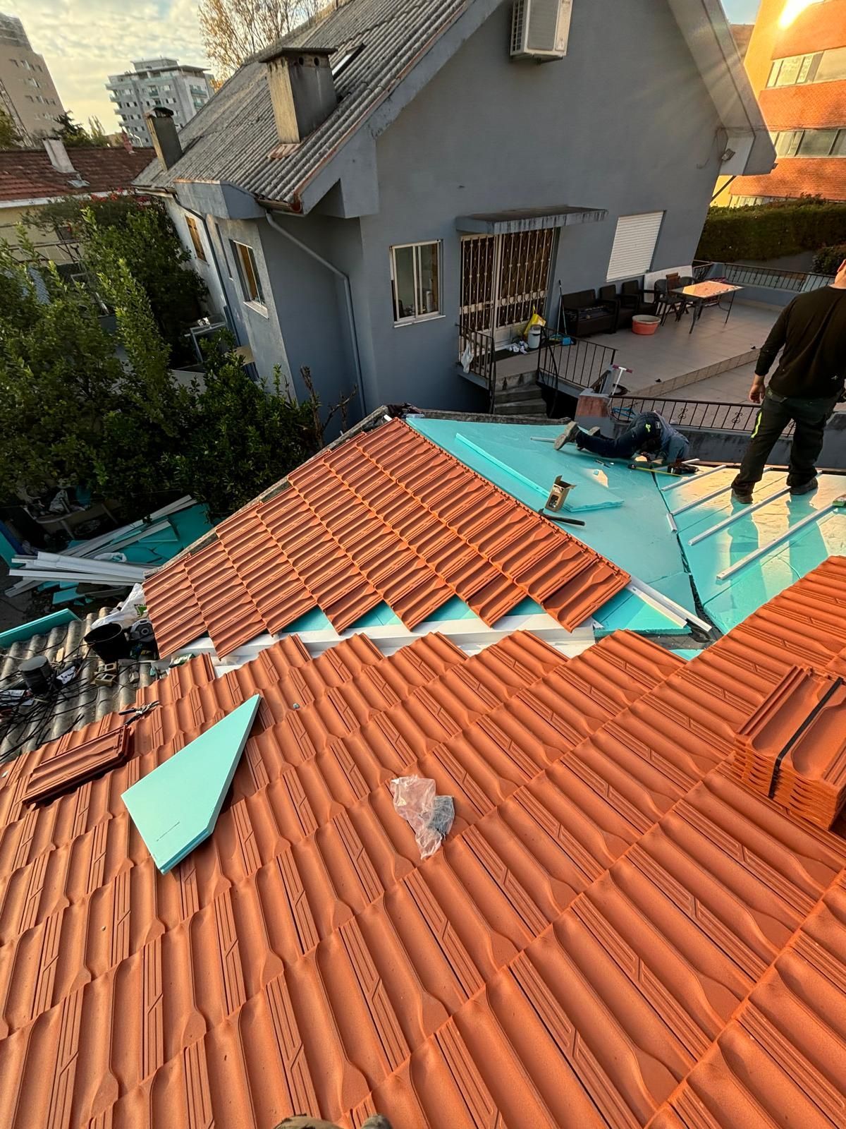 Um homem está trabalhando no telhado de uma casa.