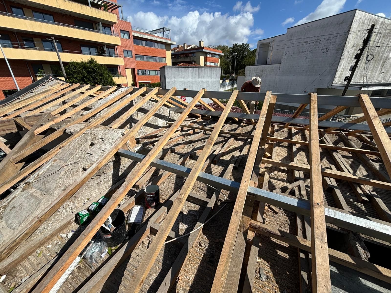 Uma estrutura de madeira está sendo construída no telhado de um edifício.