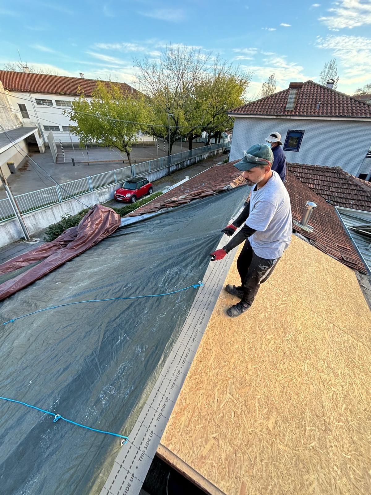 Um homem está trabalhando no telhado de uma casa.