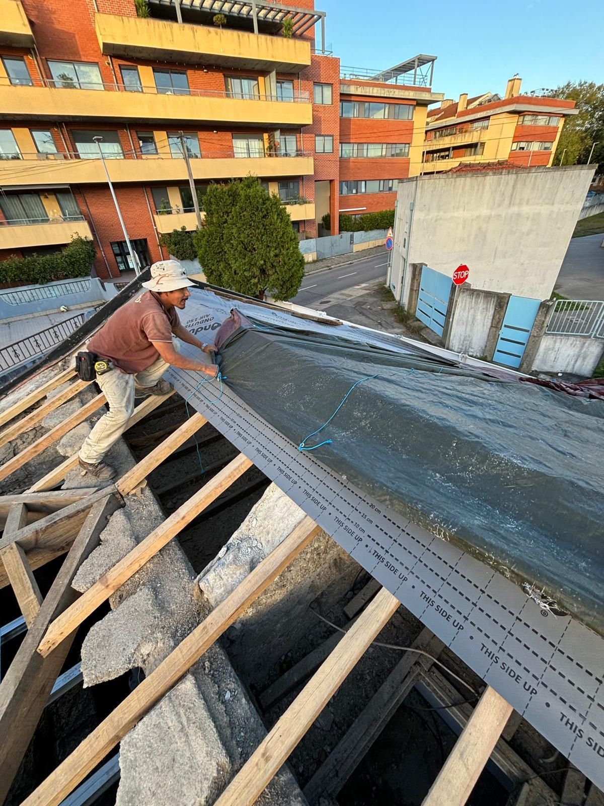 Um homem está trabalhando no telhado de um prédio.